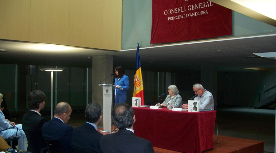 La ministra, Mònica Bonell, al faristol i, a la taula, Àngels Mach i Domènec Bascompte
