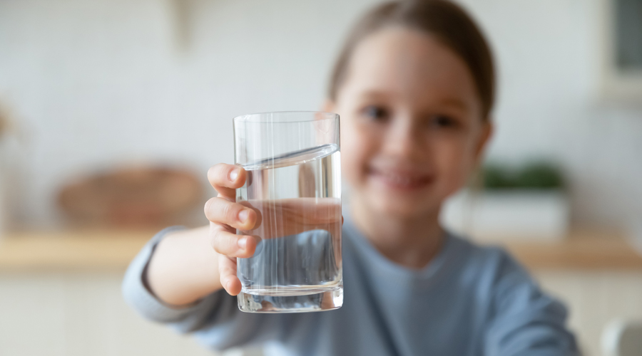 Una nena amb un got d'aigua