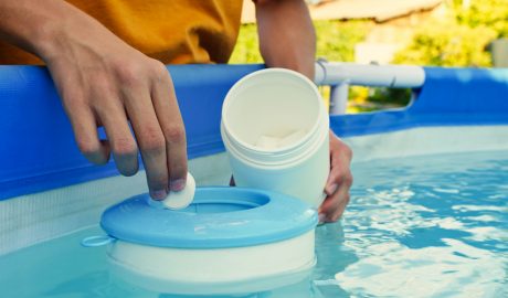 Una persona introduint clor a la piscina