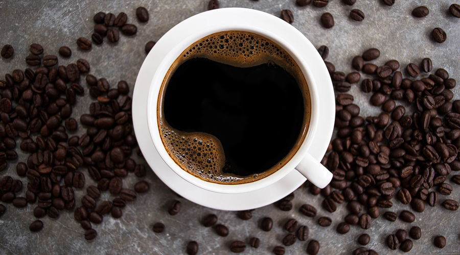 Una tassa de cafè i grans sense moldre (AMIC)