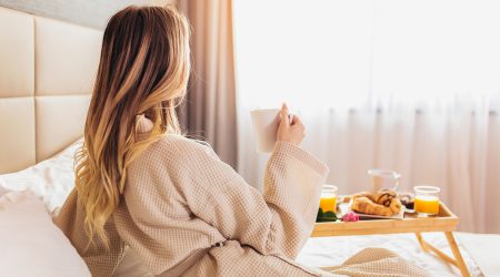 Una dona esmorzant en l'habitació d'un hotel
