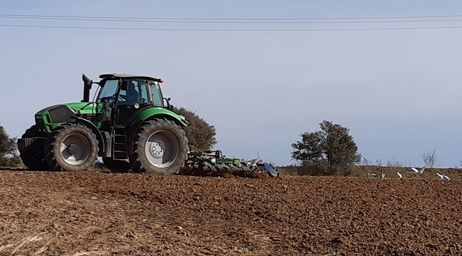 Un tractor llaurant la terra (Unió de Pagesos)