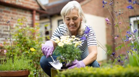 Una dona tenint cura del seu jardí