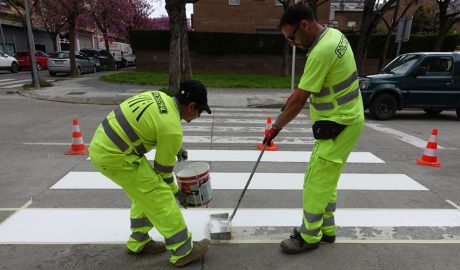 Dos operaris repintant un pas de vianants