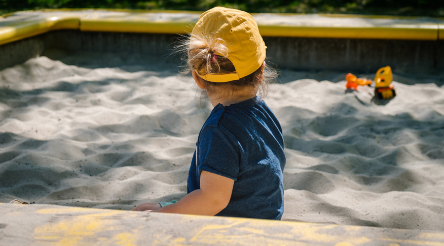 Un infant jugant en un sorral (Unsplash)