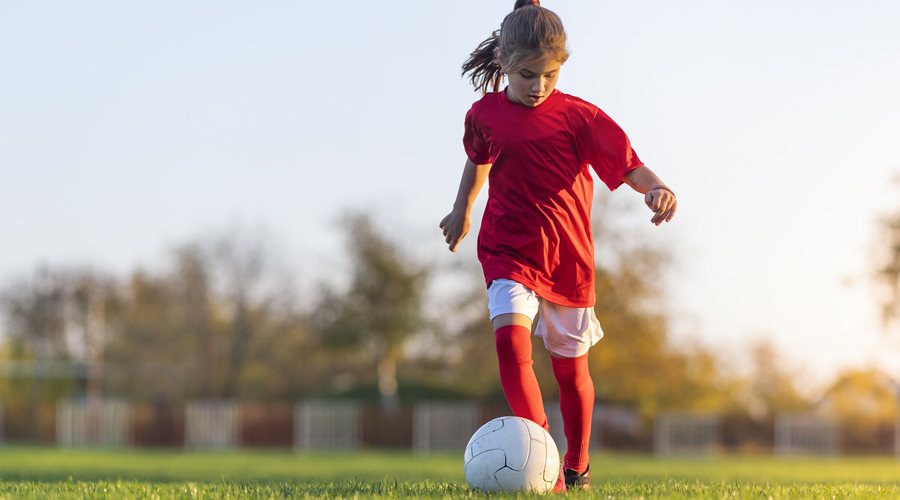 Una nena jugant a futbol (AMIC)