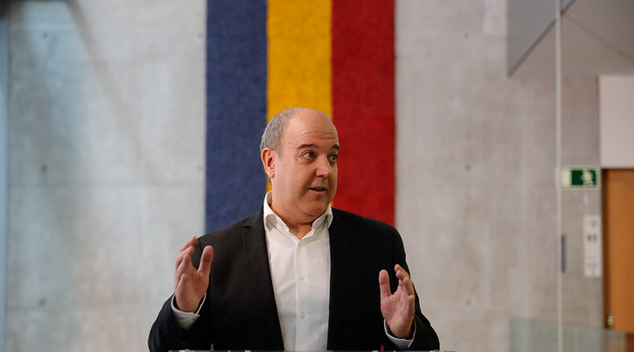 L'artista, Pere Moles, amb la seva obra en forma de bandera andorrana just al seu darrera (Consell General)
