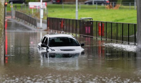 Un carrer inundat amb un cotxe atrapat