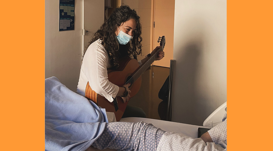 La musicoterapeuta cerdana, Laia Font, oferint la seva música a una persona malalta (Delegació de la Generalitat a Andorra)