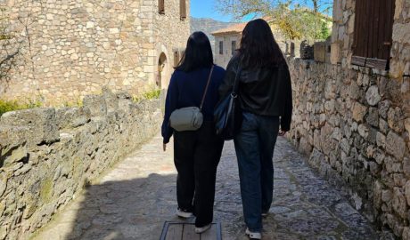 Una persona acompanyada d'un assistent personal en un poble del Pirineu