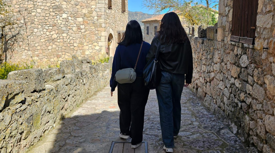 Una persona acompanyada d'un assistent personal en un poble del Pirineu