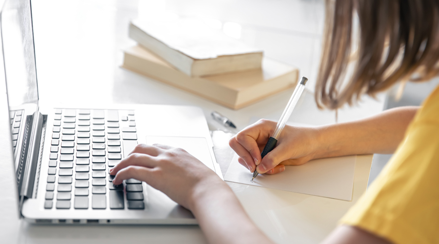 Una estudiant escrivint (Freepik)