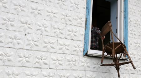 Un home fent la intenció de llençar una cadira per la finestra