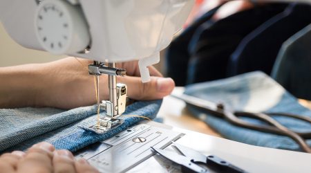 Una persona utilitzant una màquina de cosir