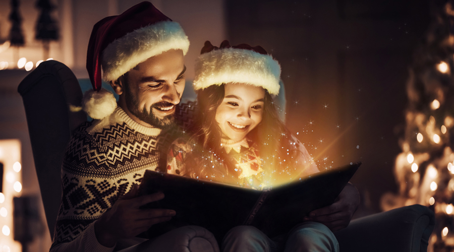 Una pare i la seva filla llegint un conte per Nadal (Getty Images)
