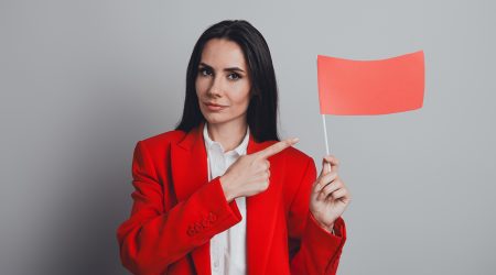 Una dona mostrant una bandera vermella -red flag-