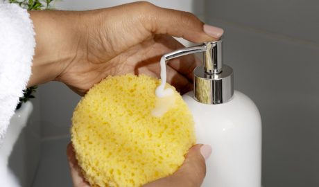 Una dona netejant-se amb una esponja i sabó