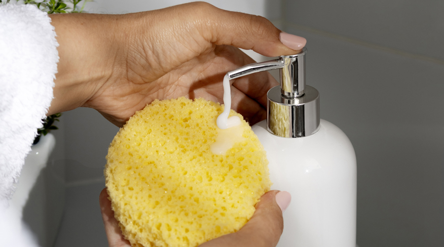 Una dona netejant-se amb una esponja i sabó