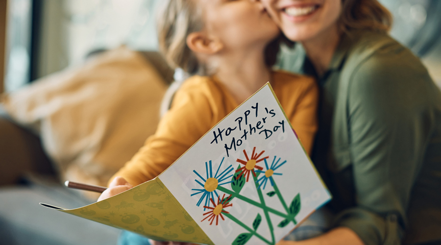 Una nena obsequiant la seva mare amb una postal