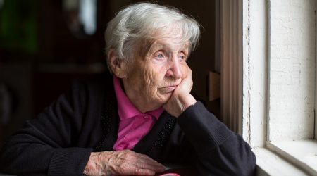 Una padrina, sola, mirant per la finestra