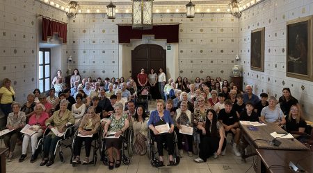 Gent gran i joves en l'acte de la sala de plens