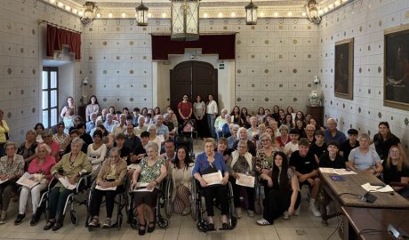 Gent gran i joves en l'acte de la sala de plens