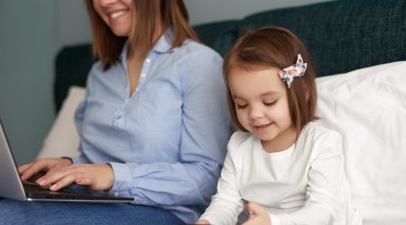 Una mare fent teletreball amb la seva filla a casa