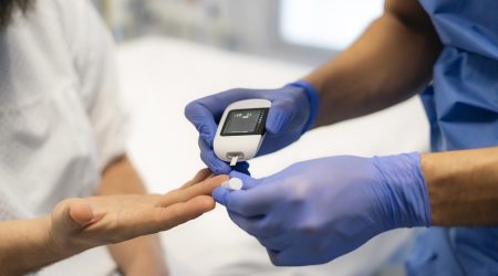 Un sanitari comprovant el nivell de glucosa en una pacient