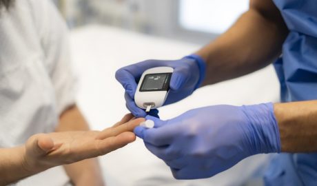 Un sanitari comprovant el nivell de glucosa en una pacient
