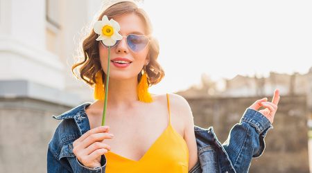 Una dona sostenint una flor i amb la pell facial sana